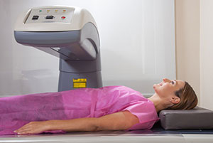 Photo of a lady getting scanned by diagnostic equipment to identify the cause of pain