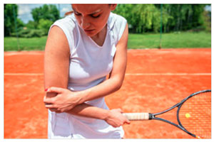 Tennis player holding her arm in pain